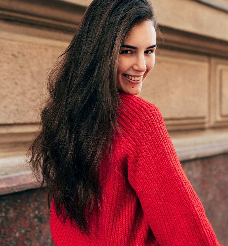 woman in red sweater looking over her shoulder