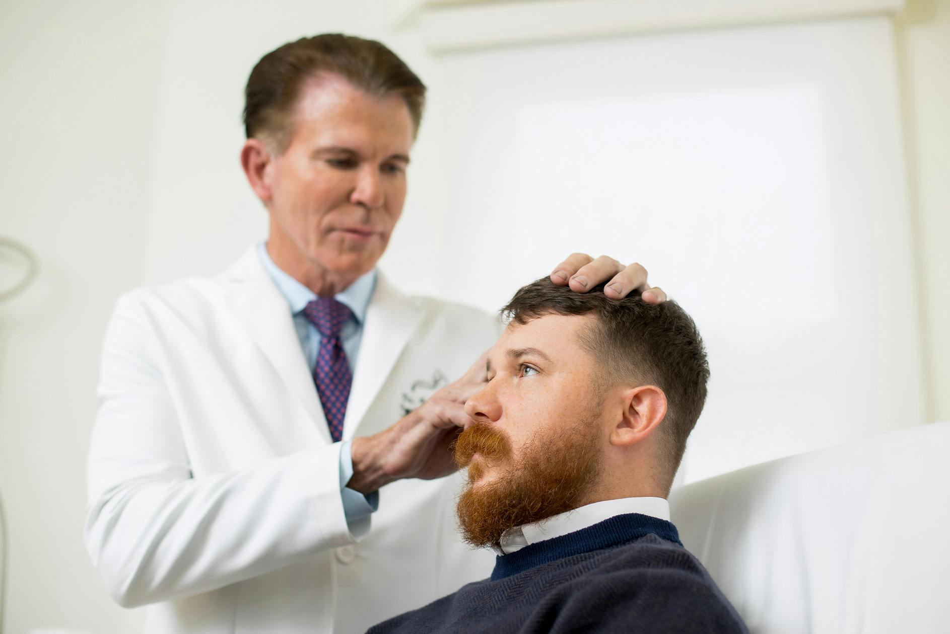 male patient having hair examined by doctor