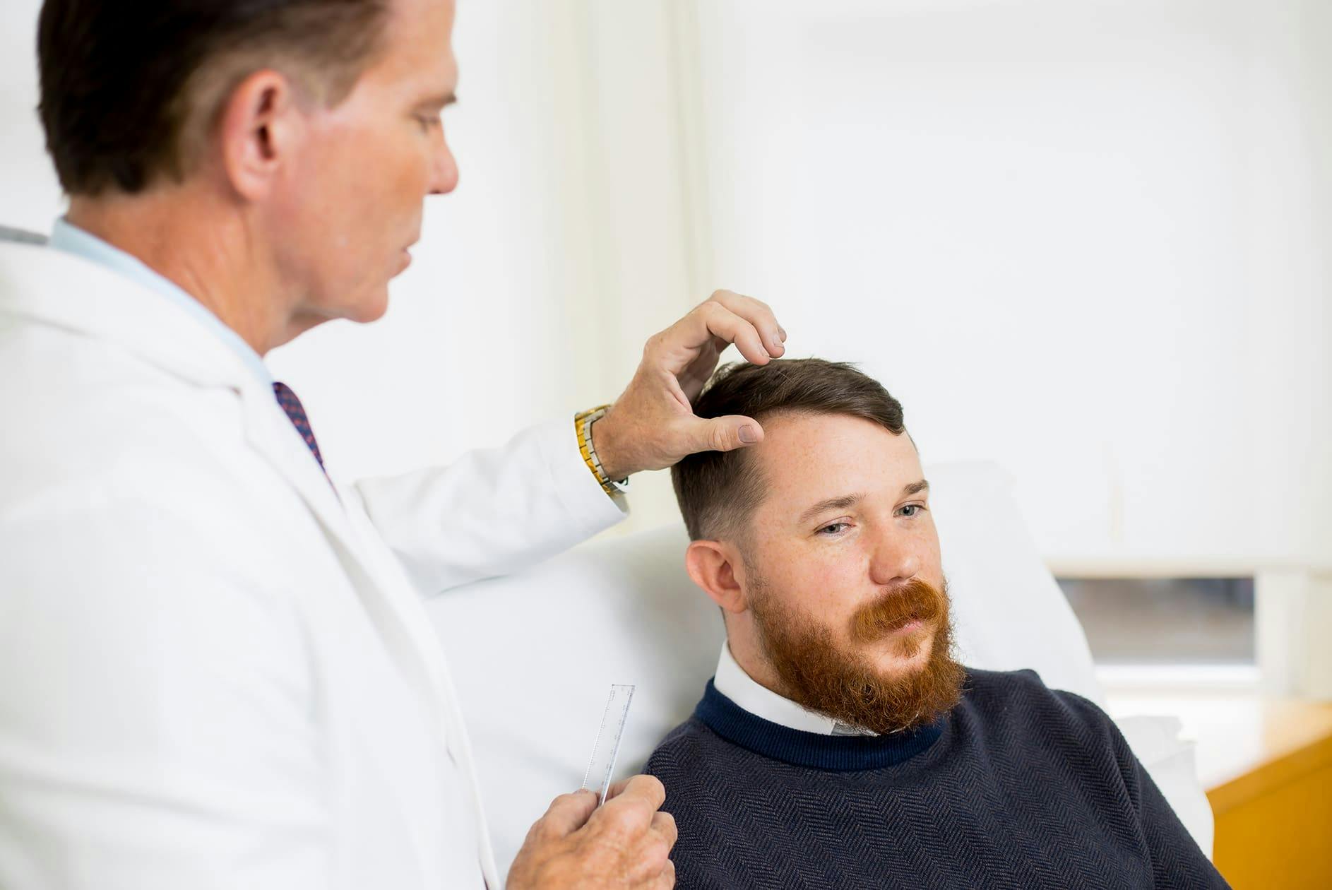 patient getting hairline examined by doctor