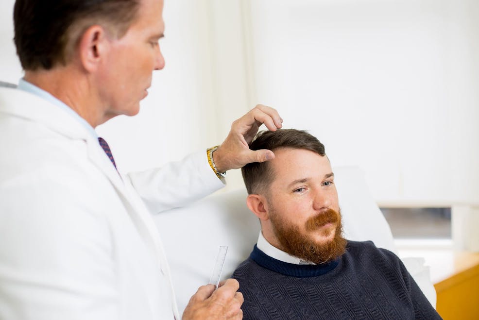 patient getting hairline examined by doctor
