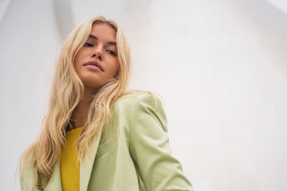 woman in light green suit jacket and blonde hair