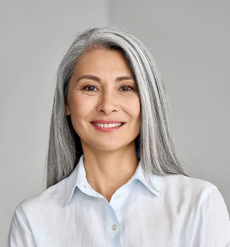 woman with gray straight hair smiling forward