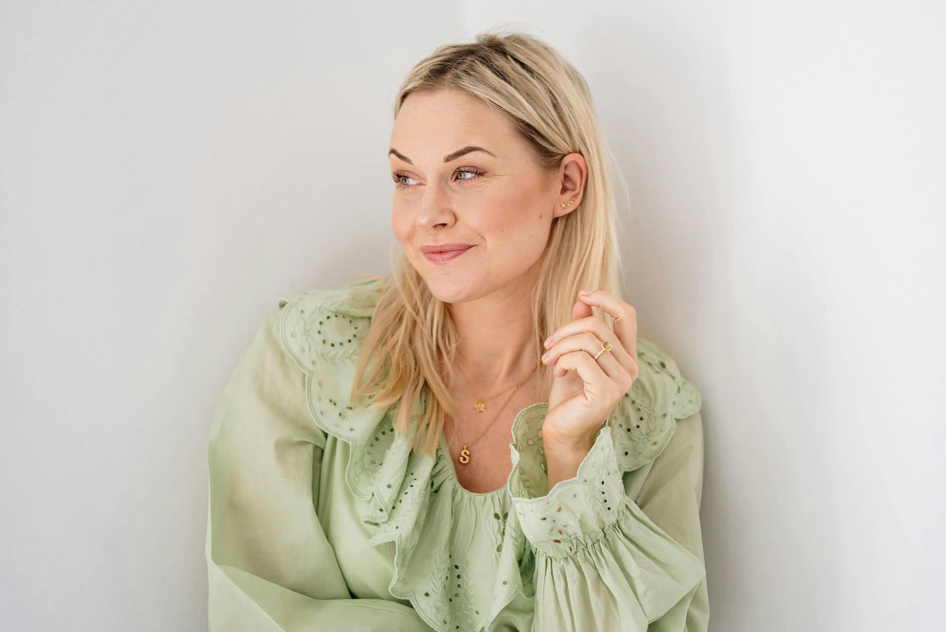 blonde woman with light green top looking to the left