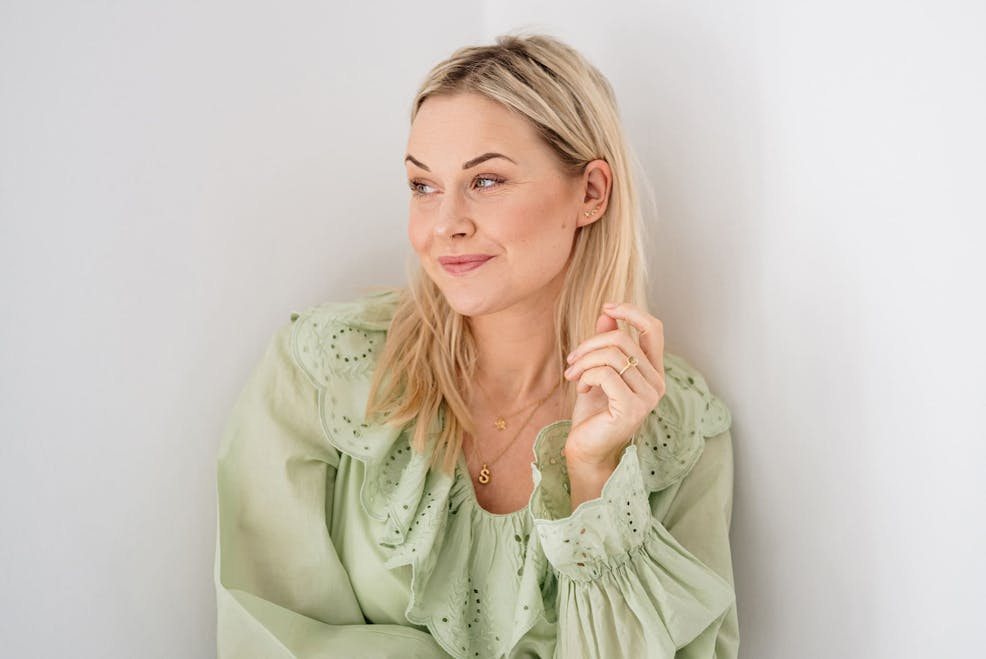 blonde woman with light green top looking to the left