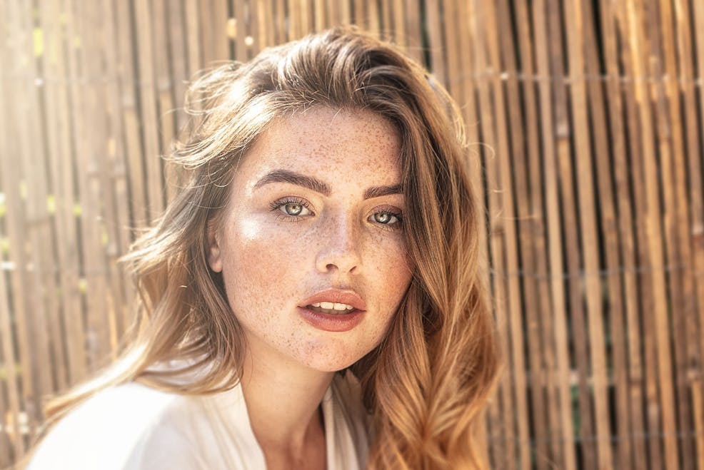 woman with freckles looking forward with her lips slightly parted