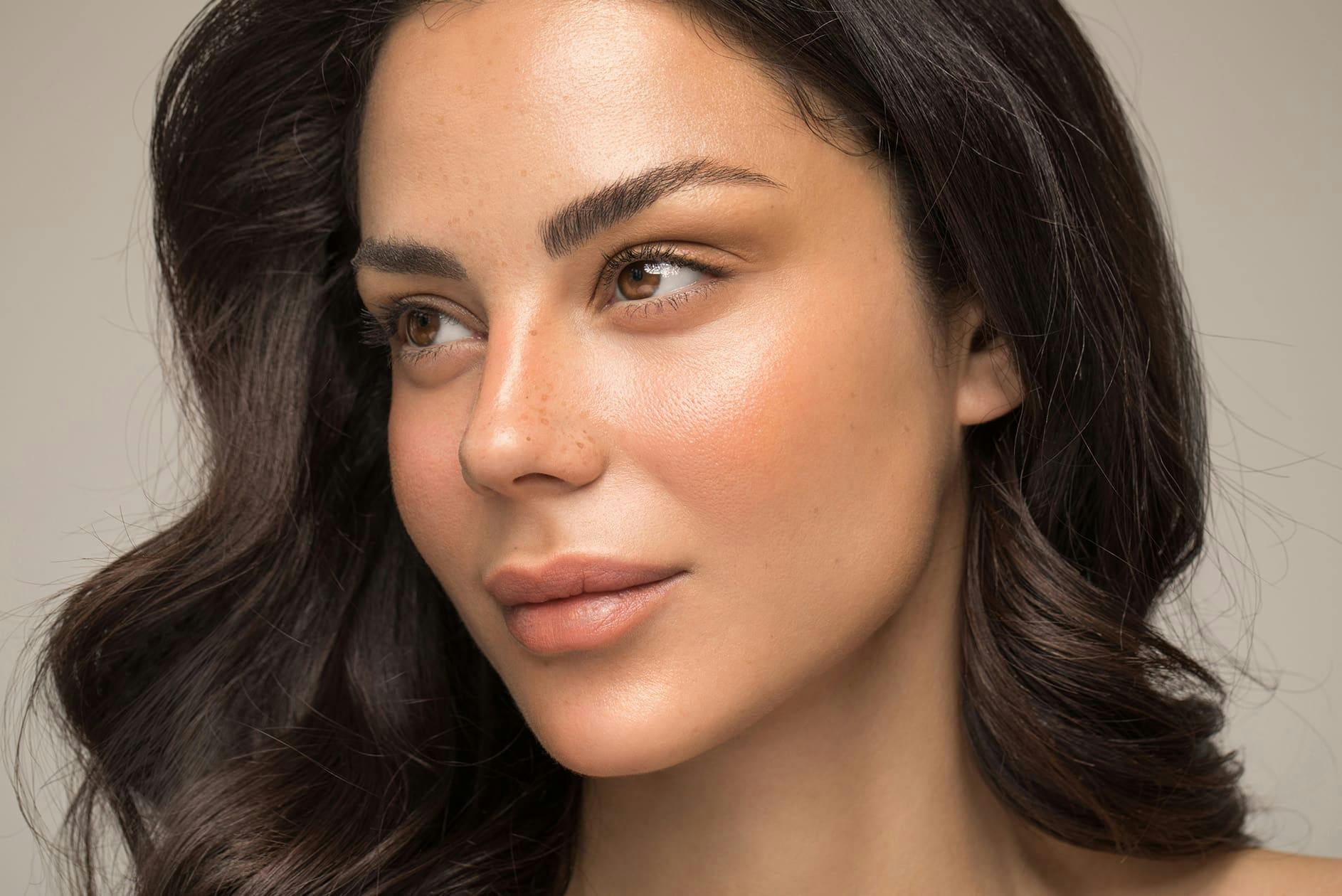 woman with brown wavy hair looking to the left