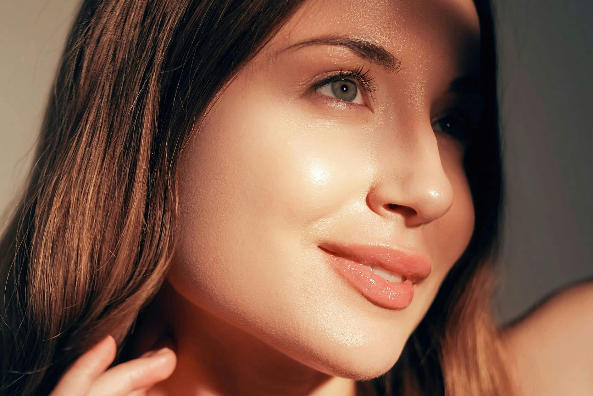 woman looking to the side with sunlight hitting her cheek as she smiles