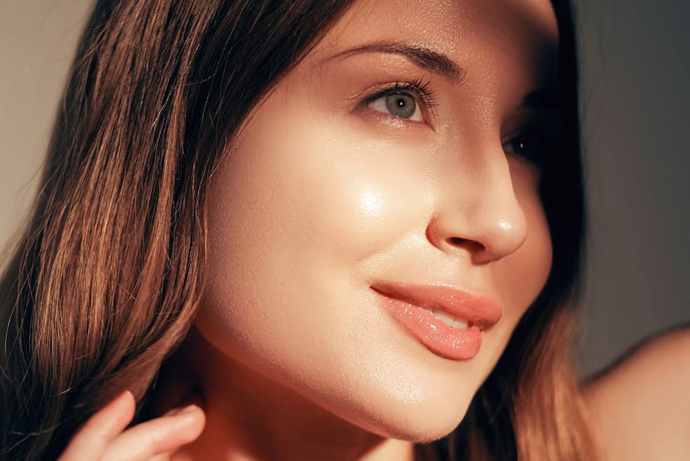 woman looking to the side with sunlight hitting her cheek as she smiles