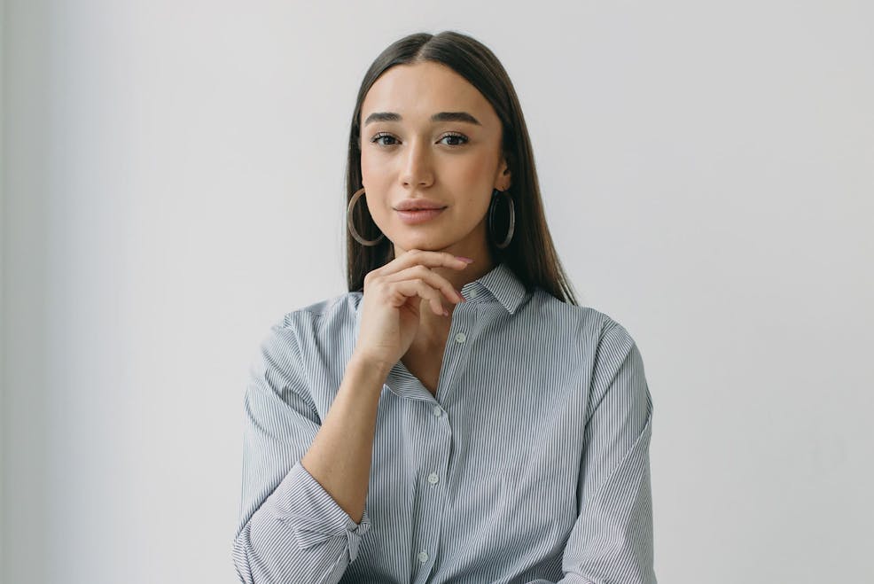 woman with her hand under her chin looking forward
