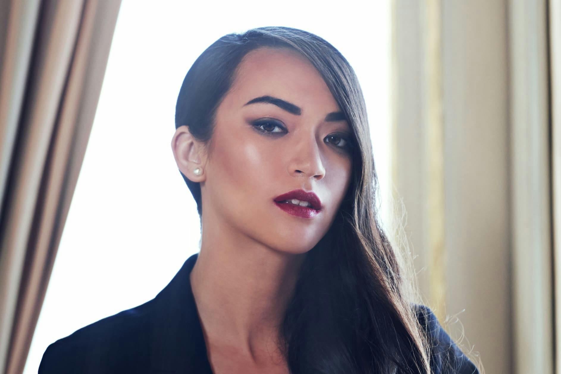 woman with smokey eye shadow and red lips with hair on one side of her head