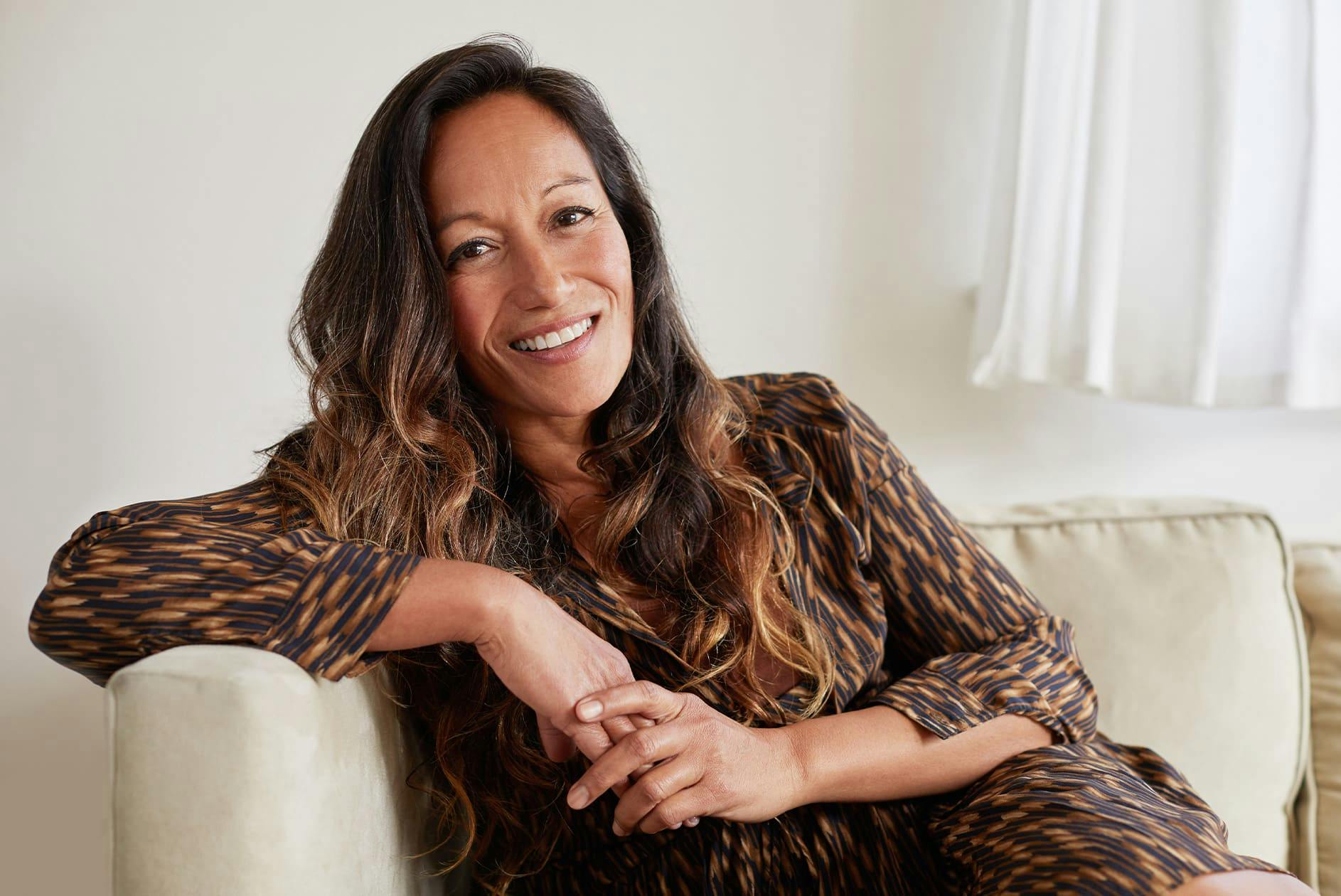 woman smiling and leaning on the couch