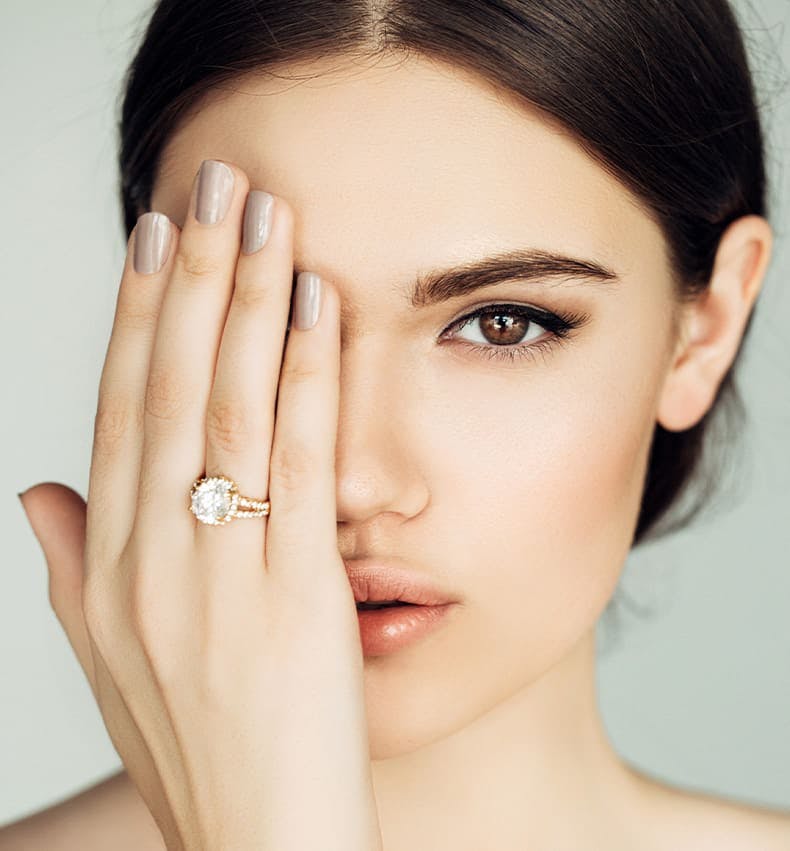 woman looking forward with one hand covering an eye