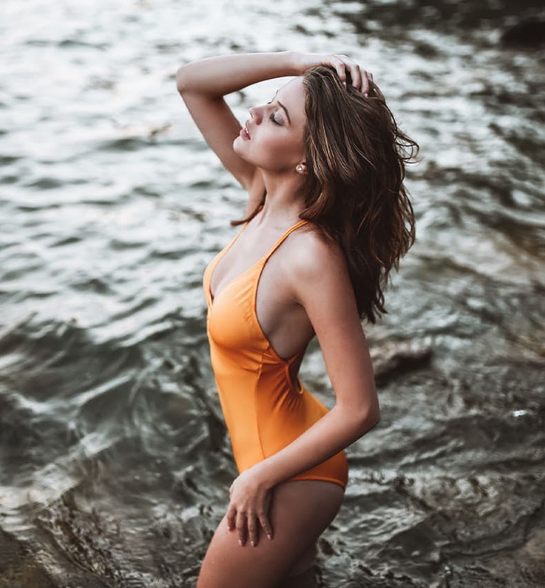 woman in the water in orange bathing suit