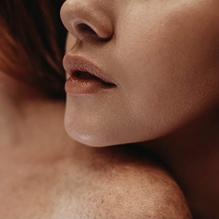 Woman with her chin over another woman's shoulder