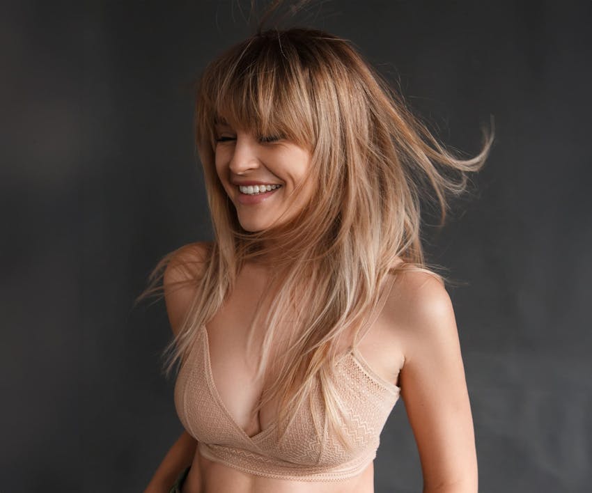 woman smiling in beige bra
