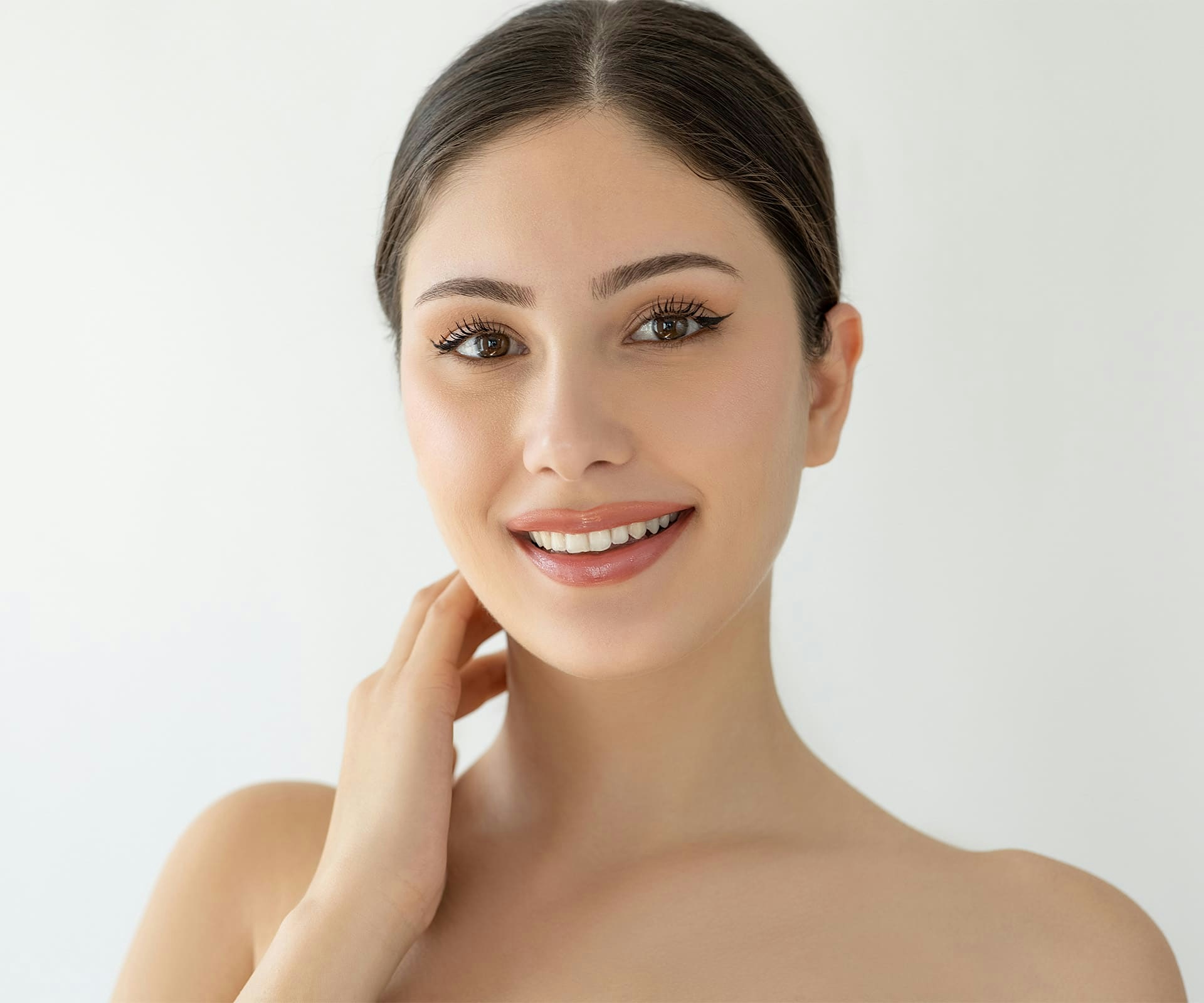 woman looking forward with her hands near her neck