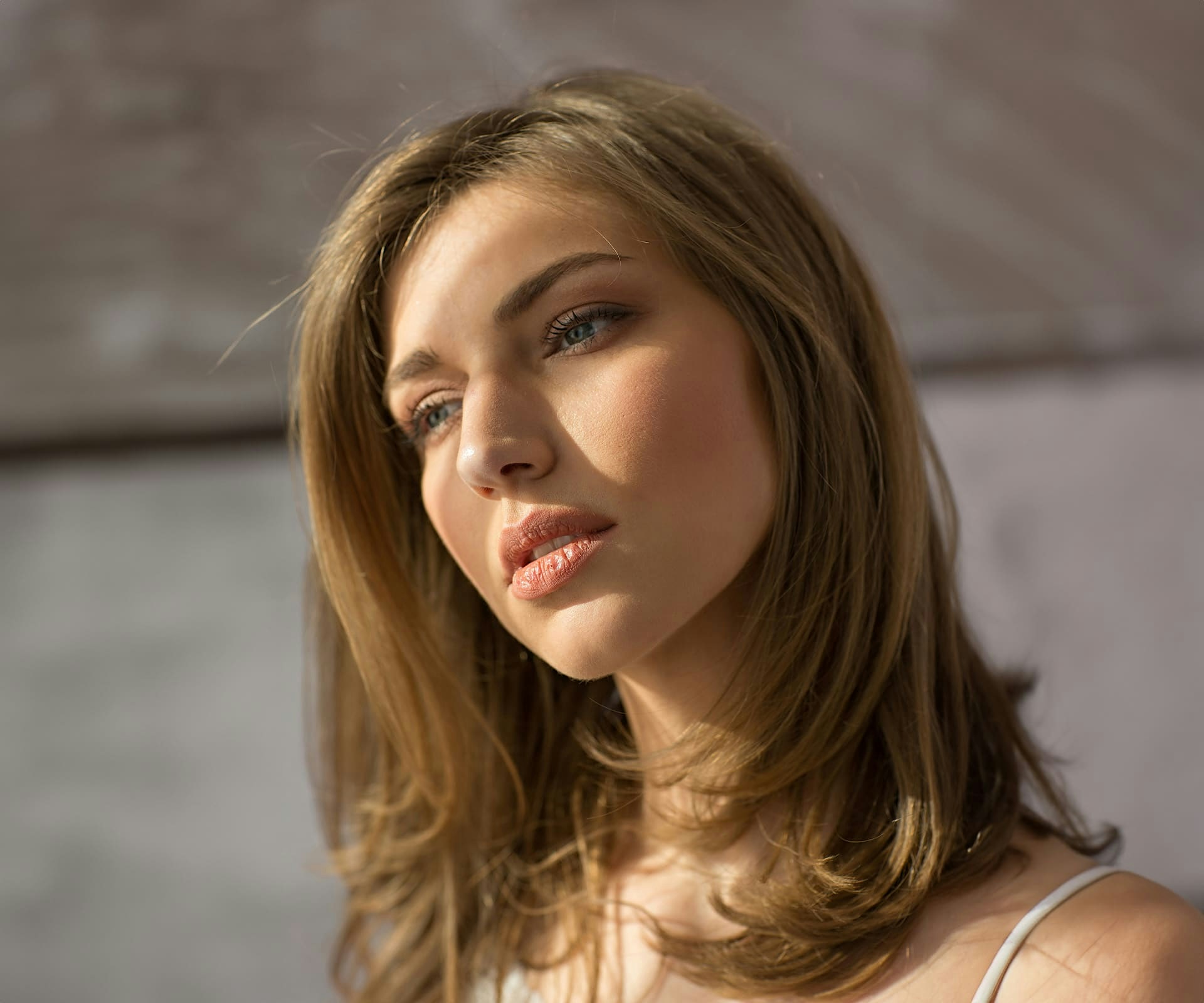 close up on woman's face with sunlight hitting her forehead
