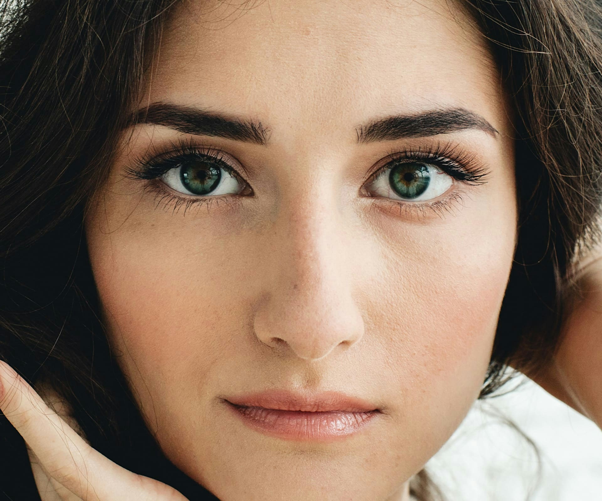 close up on woman's face with dark green hair