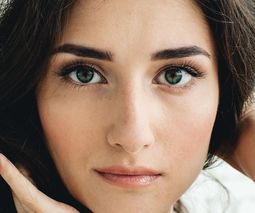 close up on woman's face with dark green hair