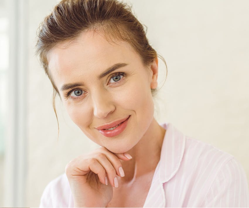 woman smiling forward with her chin resting on her hand