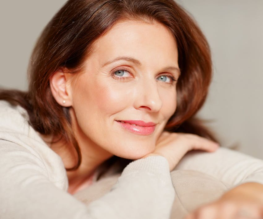 woman with red hair leaning on table