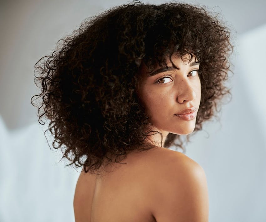 woman with afro looking over her shoulder