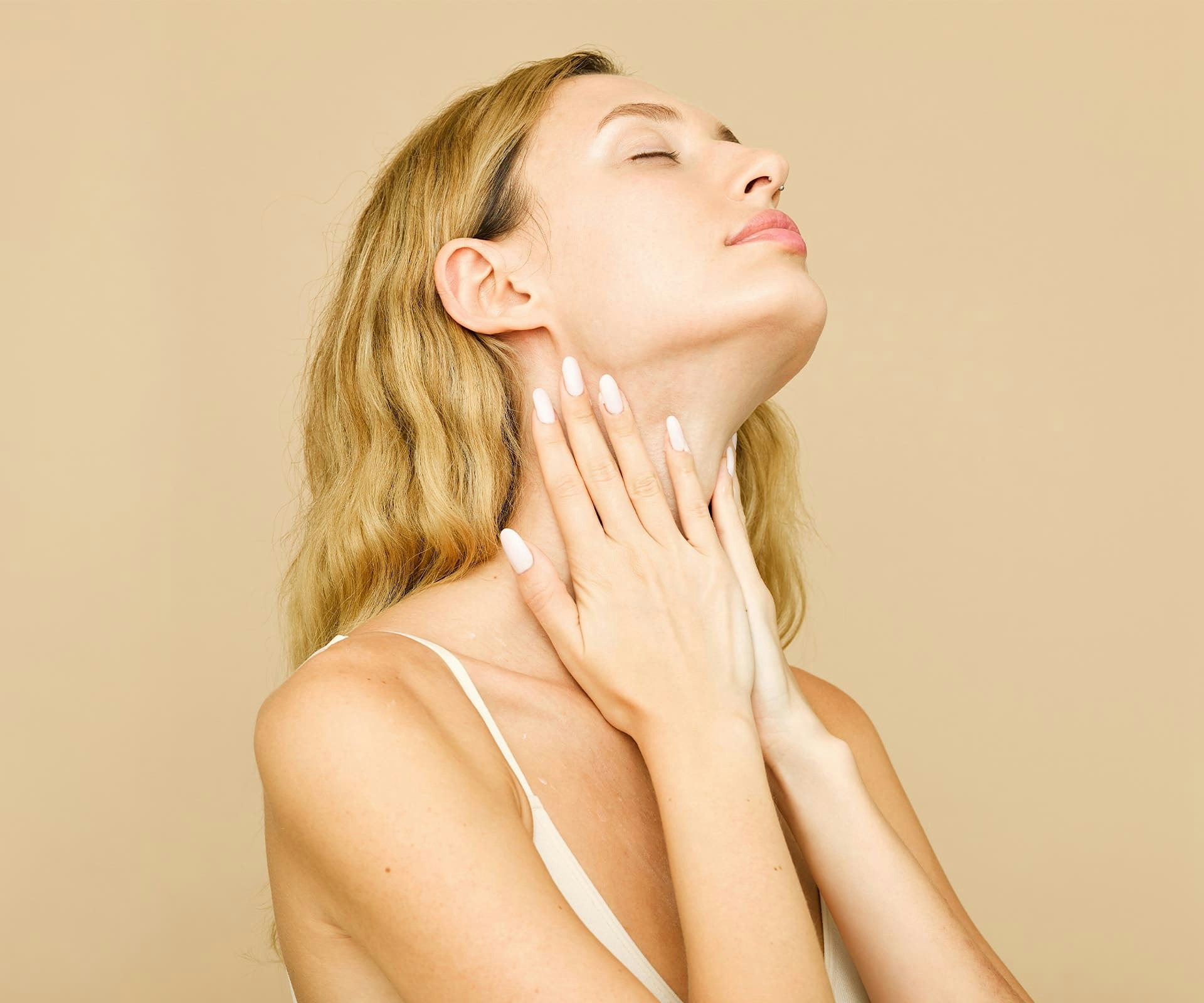 woman touching her neck with her head tilted back