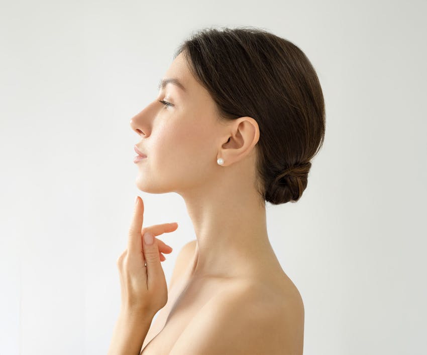 side profile of a woman face with her hand pointing towards her chin