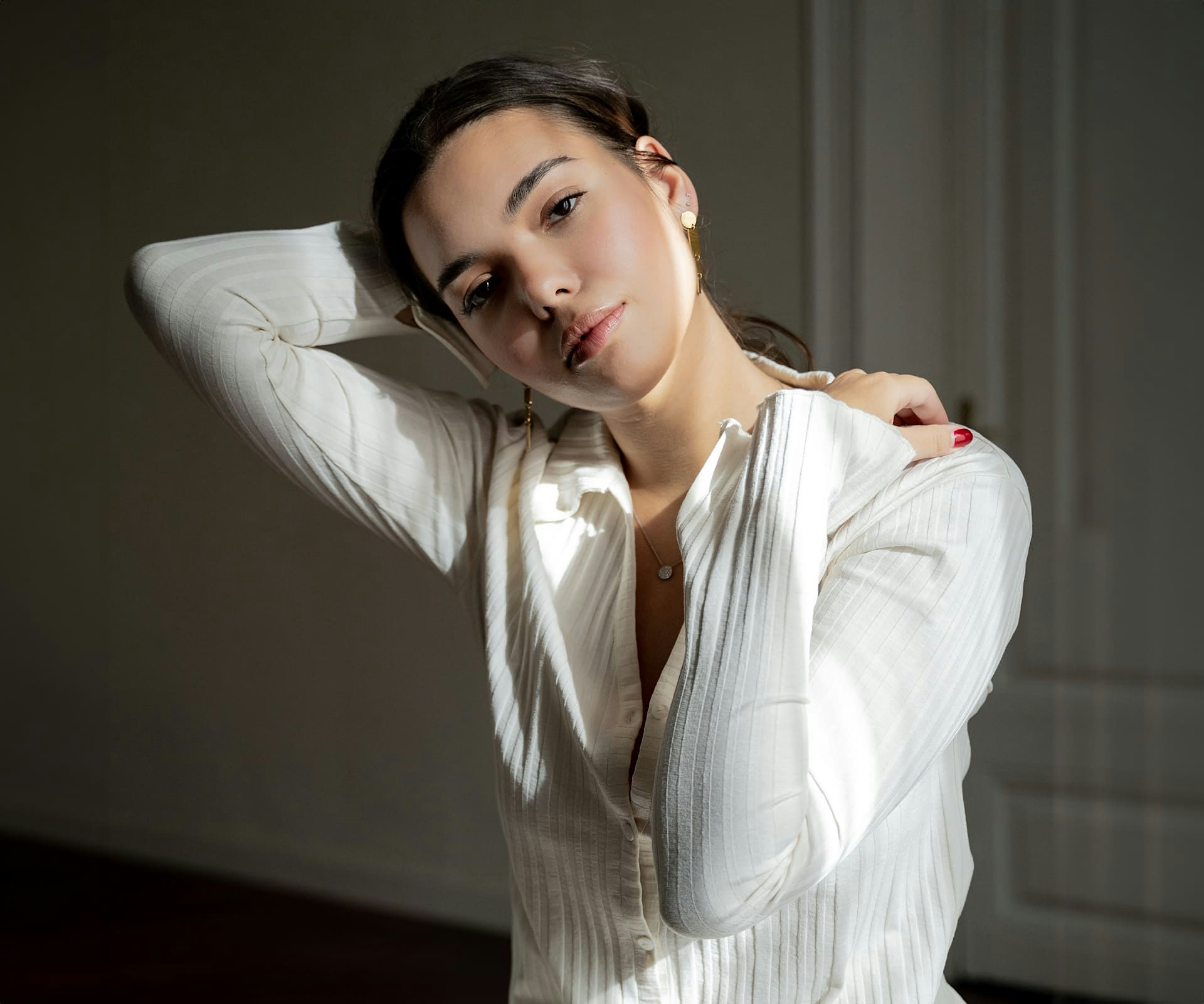 woman with her head tilted and her hand on the back of her head