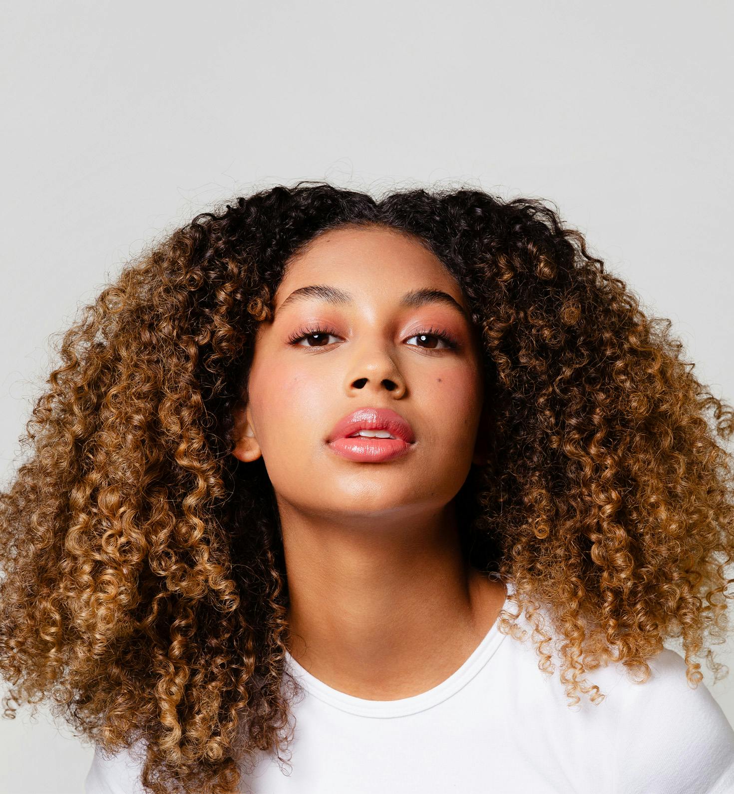 woman with tightly curled hair looking forward