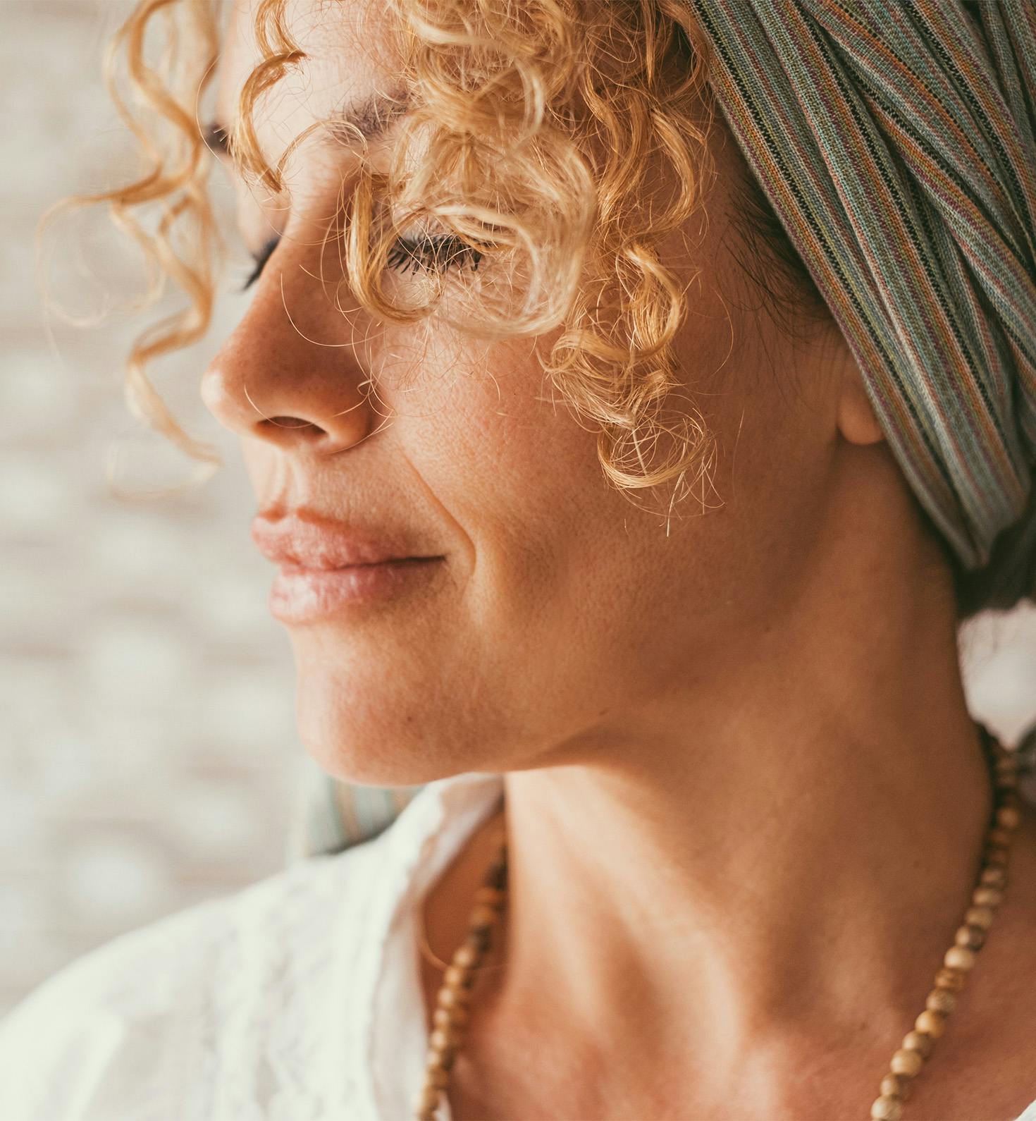 close up of woman's face with her hair wrapped in scarf