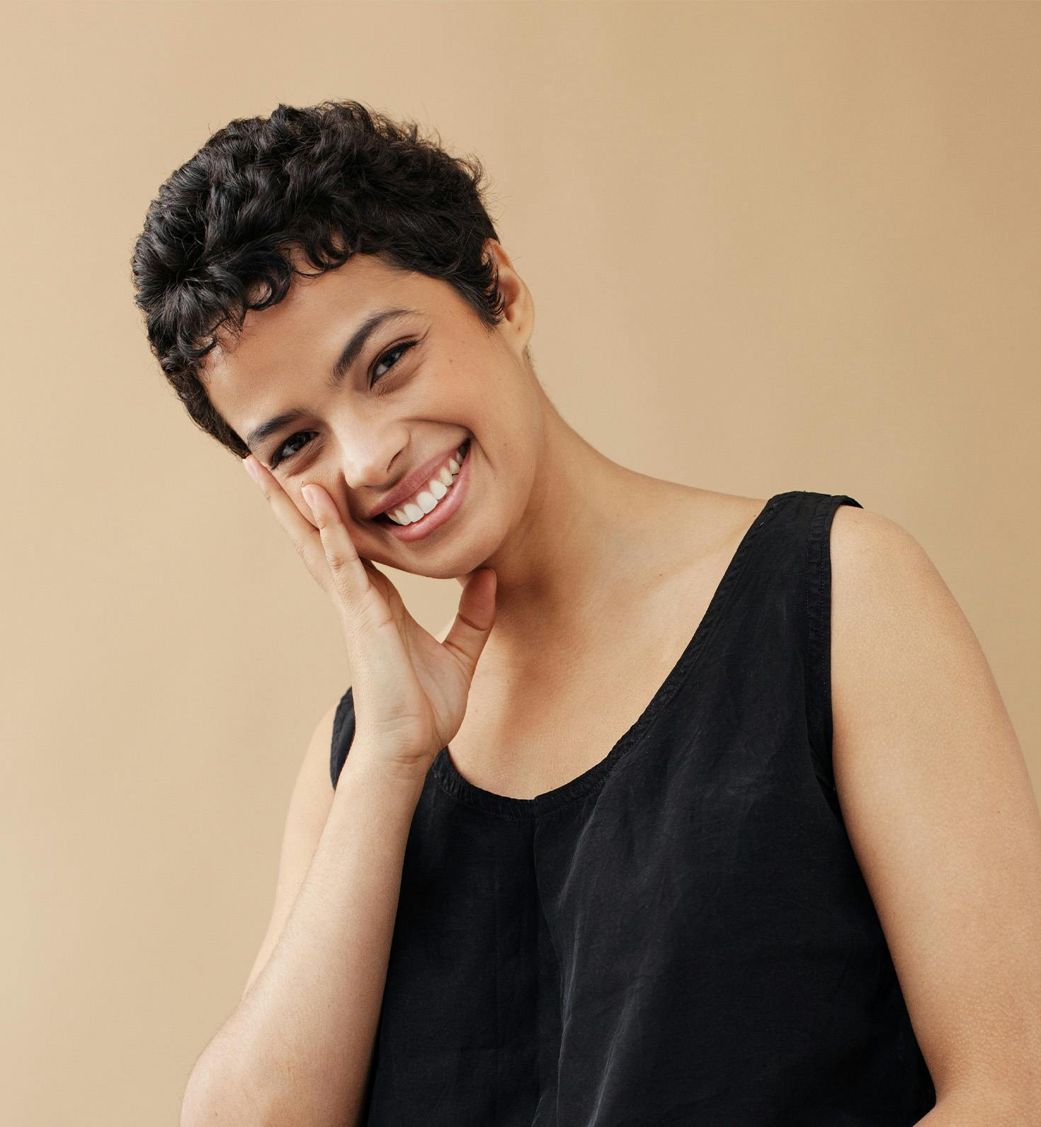 woman with short haircut touching her cheeks