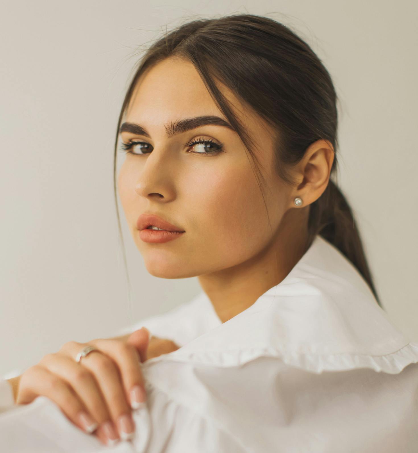 side profile of woman looking forward with her hair in a low ponytail