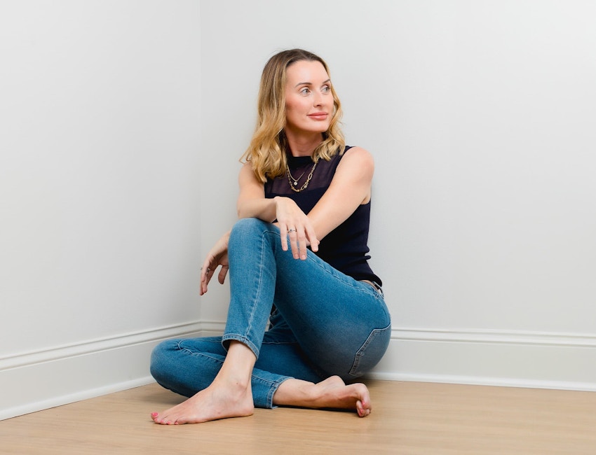 woman sitting in the corner with her arm resting on her knee
