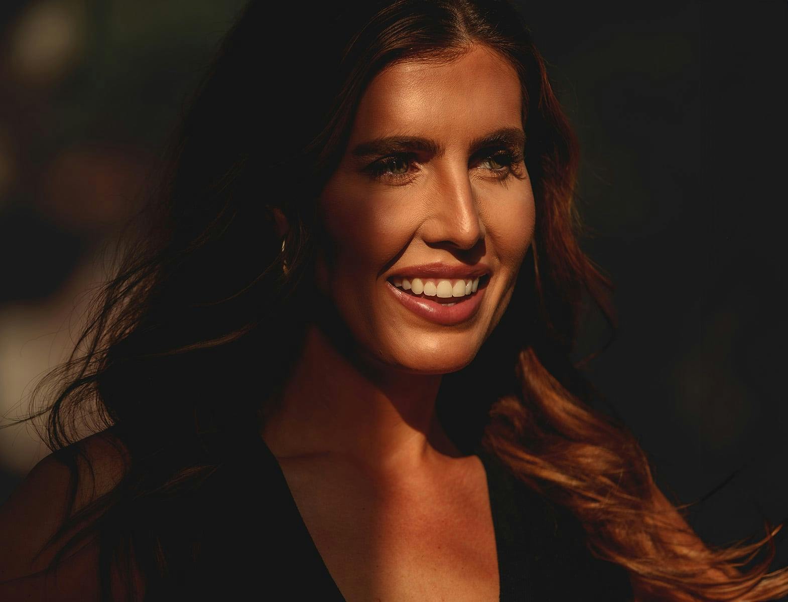 woman smiling with sun hitting the right side of her face