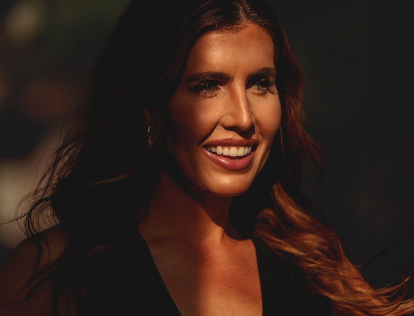 woman smiling with sun hitting the right side of her face