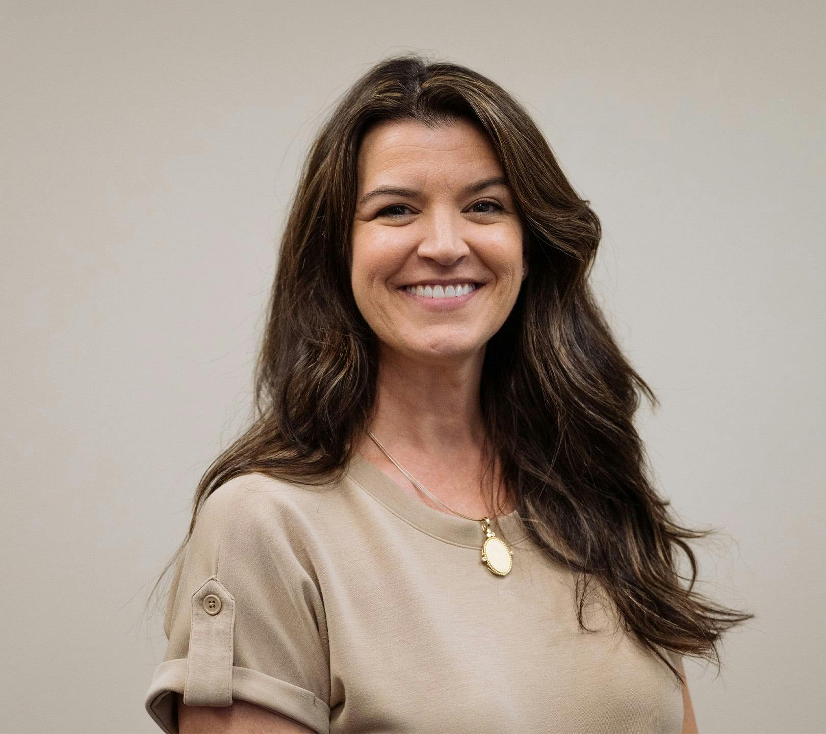 woman with beige top smiling