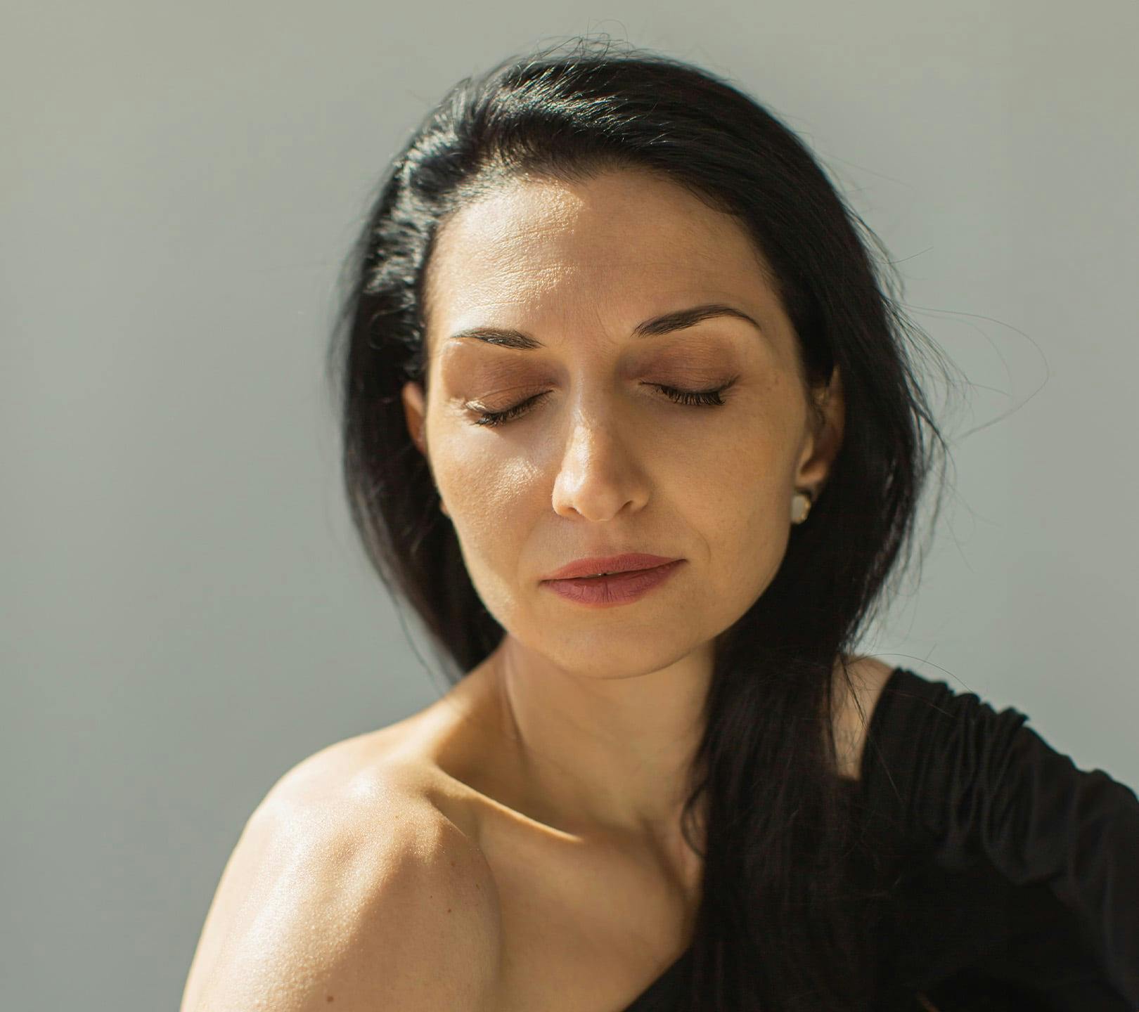 woman facing forward with her eyes closed