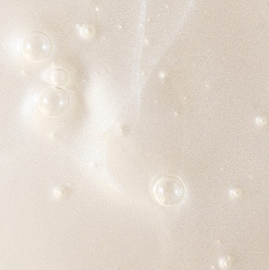Close-up of clear serum bubbles on pale background