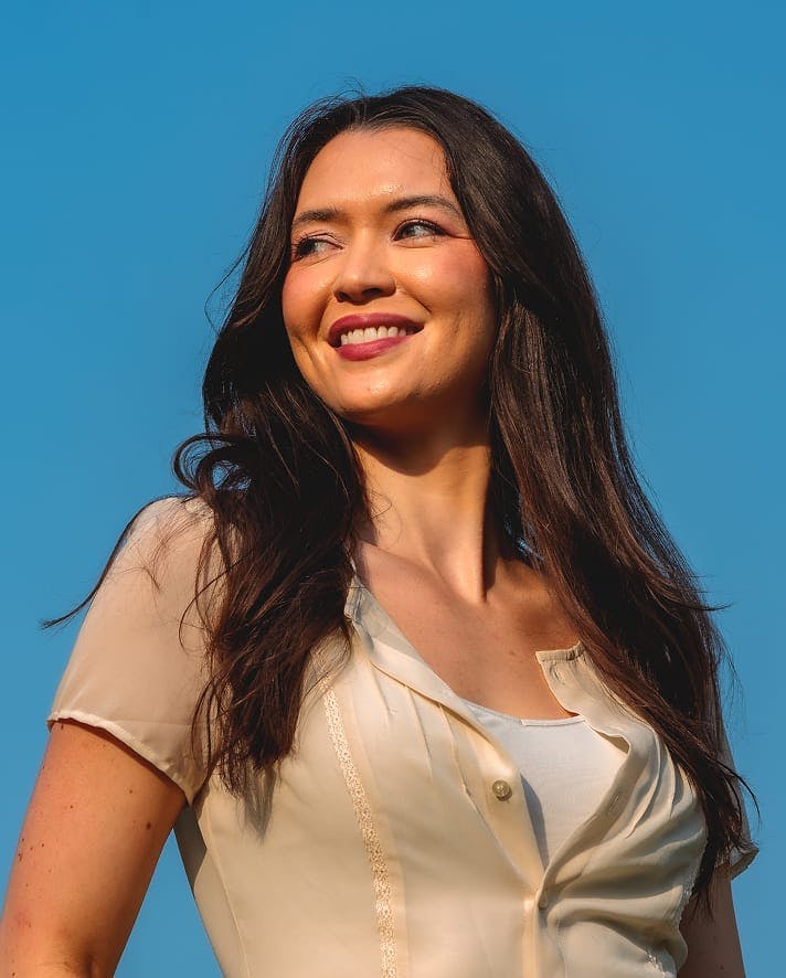 Woman smiling under a clear blue sky