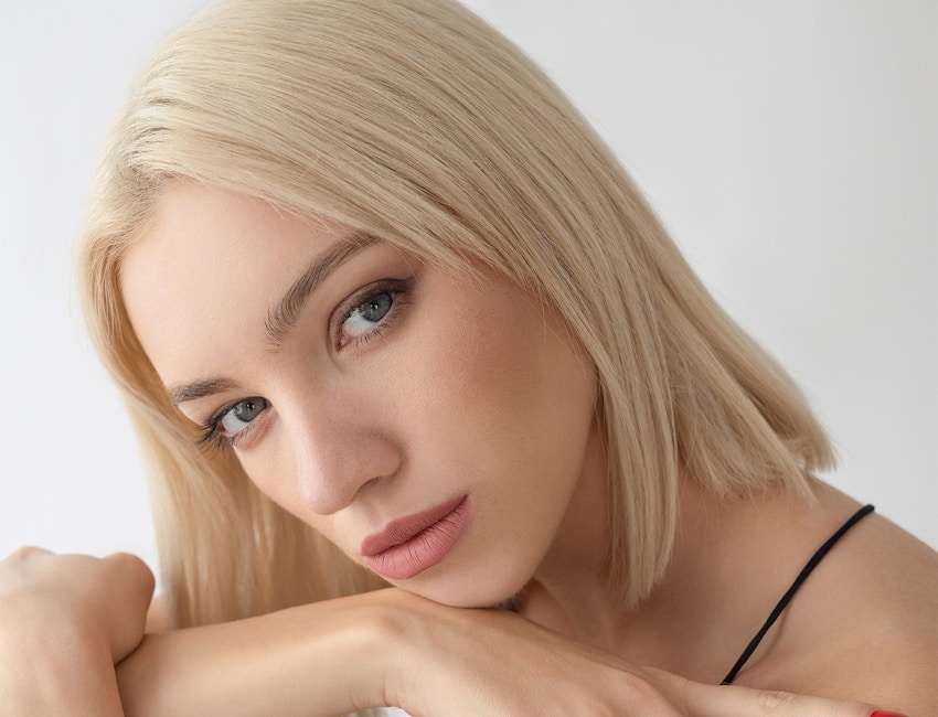 Blonde woman resting chin on arms