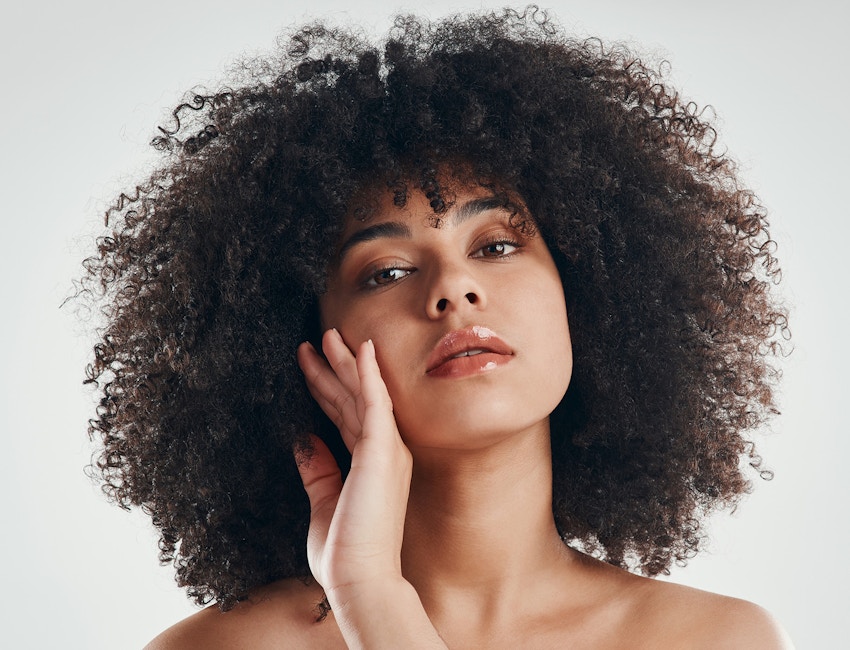 Woman touching face with back of hand