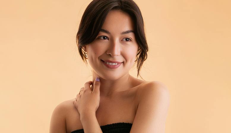 woman with a clear face and minimalist jewelry