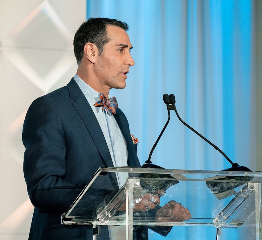Dr. Kevin Sadati speaking on stage into a microphone