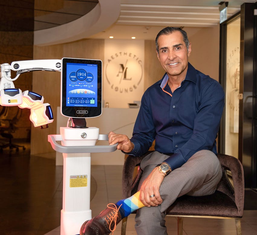 Dr. Sadati sitting in chair next to machine