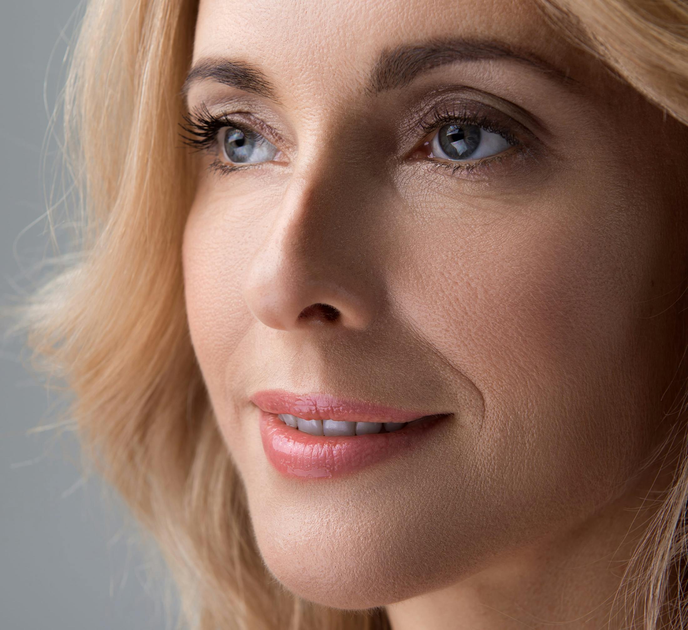 close up of blonde woman's face while she smiles looking forward