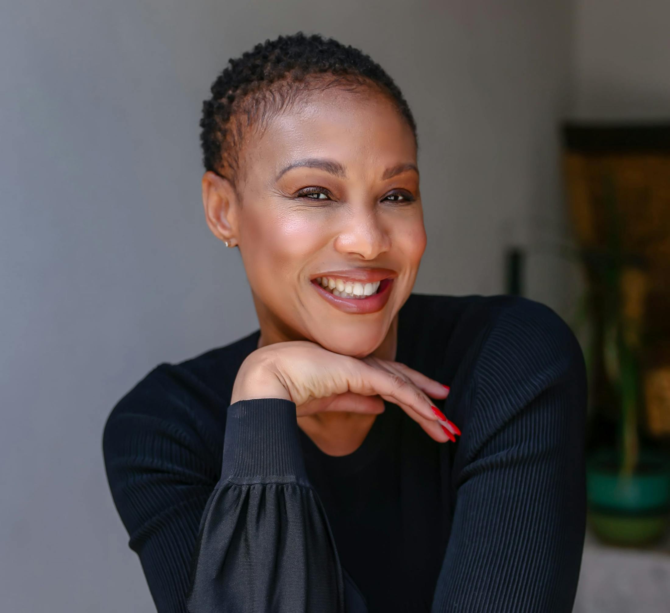 African American woman in black long sleeve shirt with her hand placed under his chin