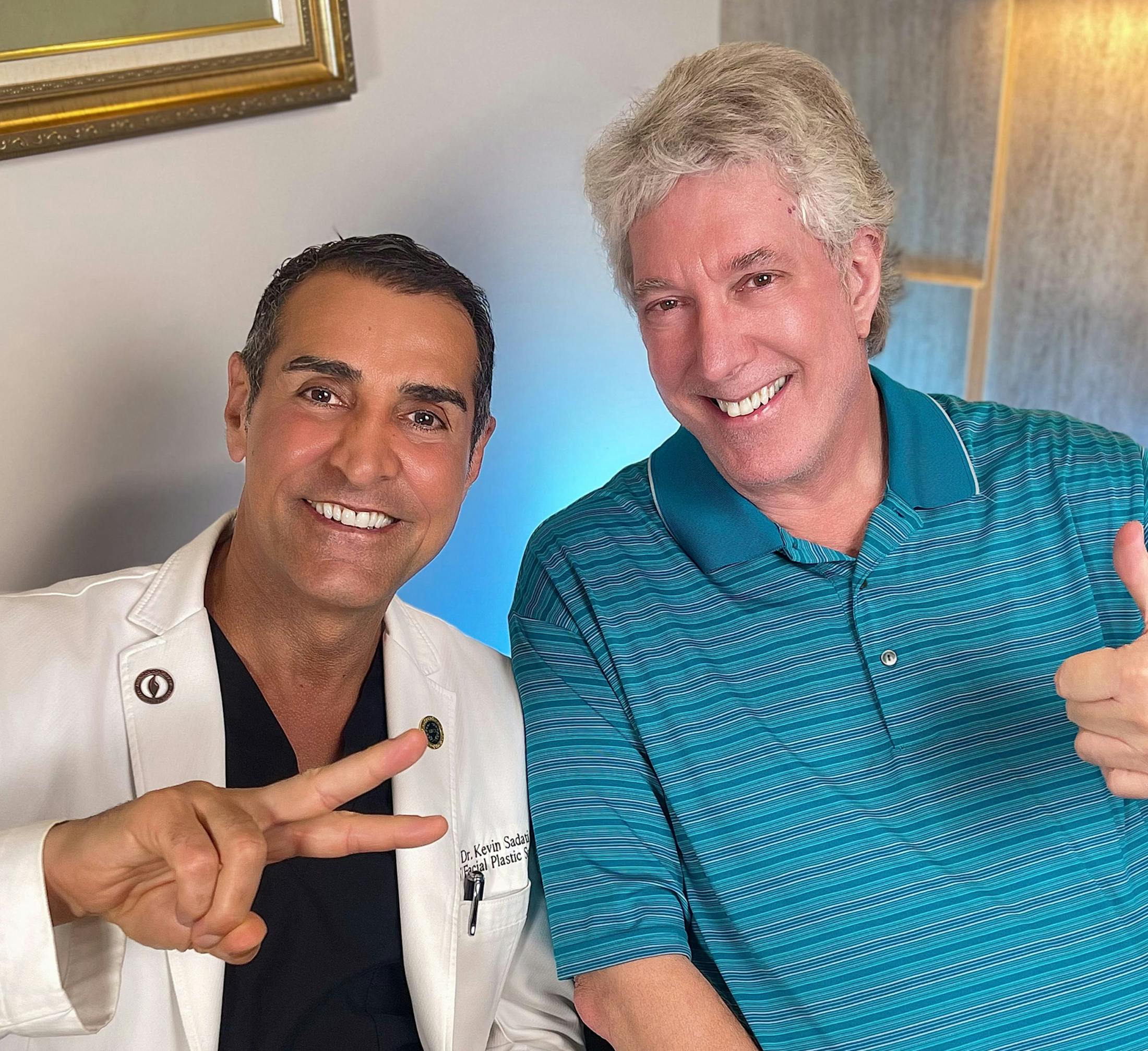 Dr. Kevin Sadati with male patient making a peace sign, while patient gives a thumbs up