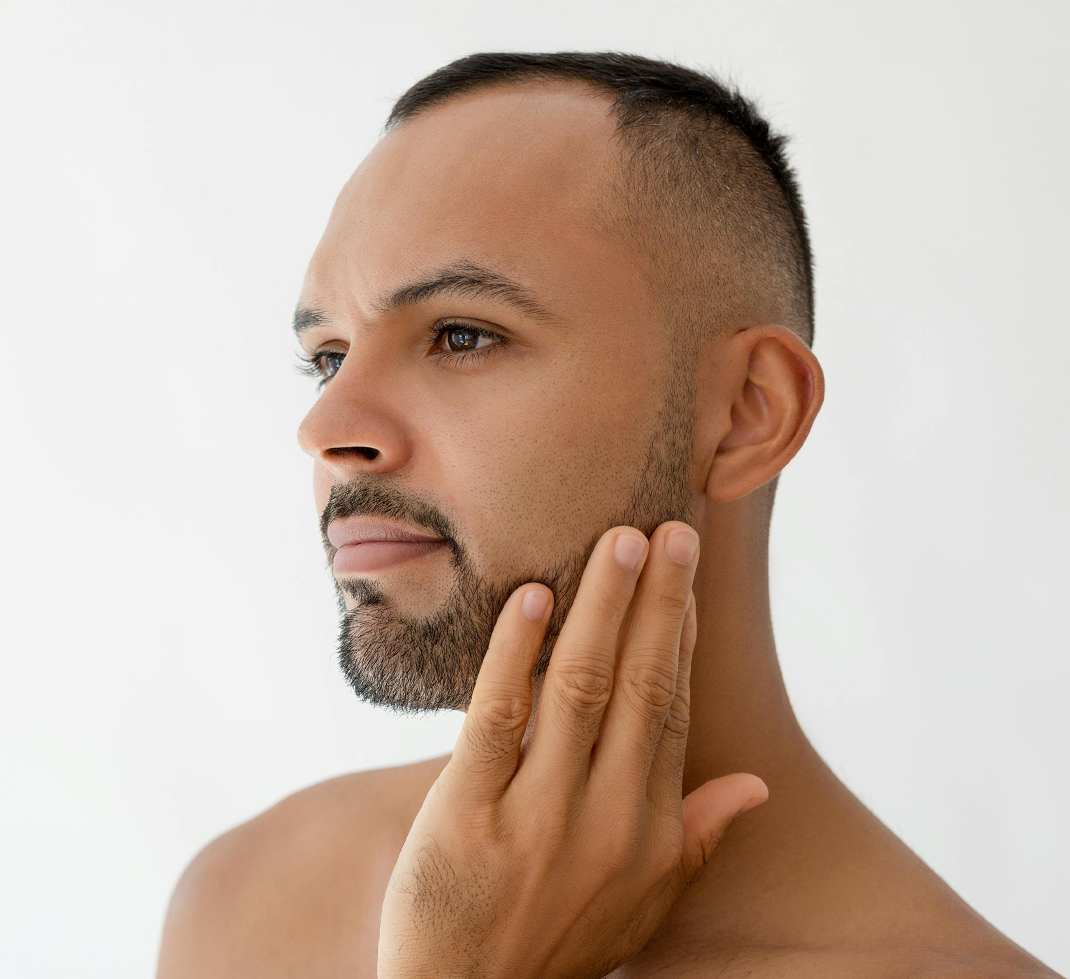 man touching the side of his face