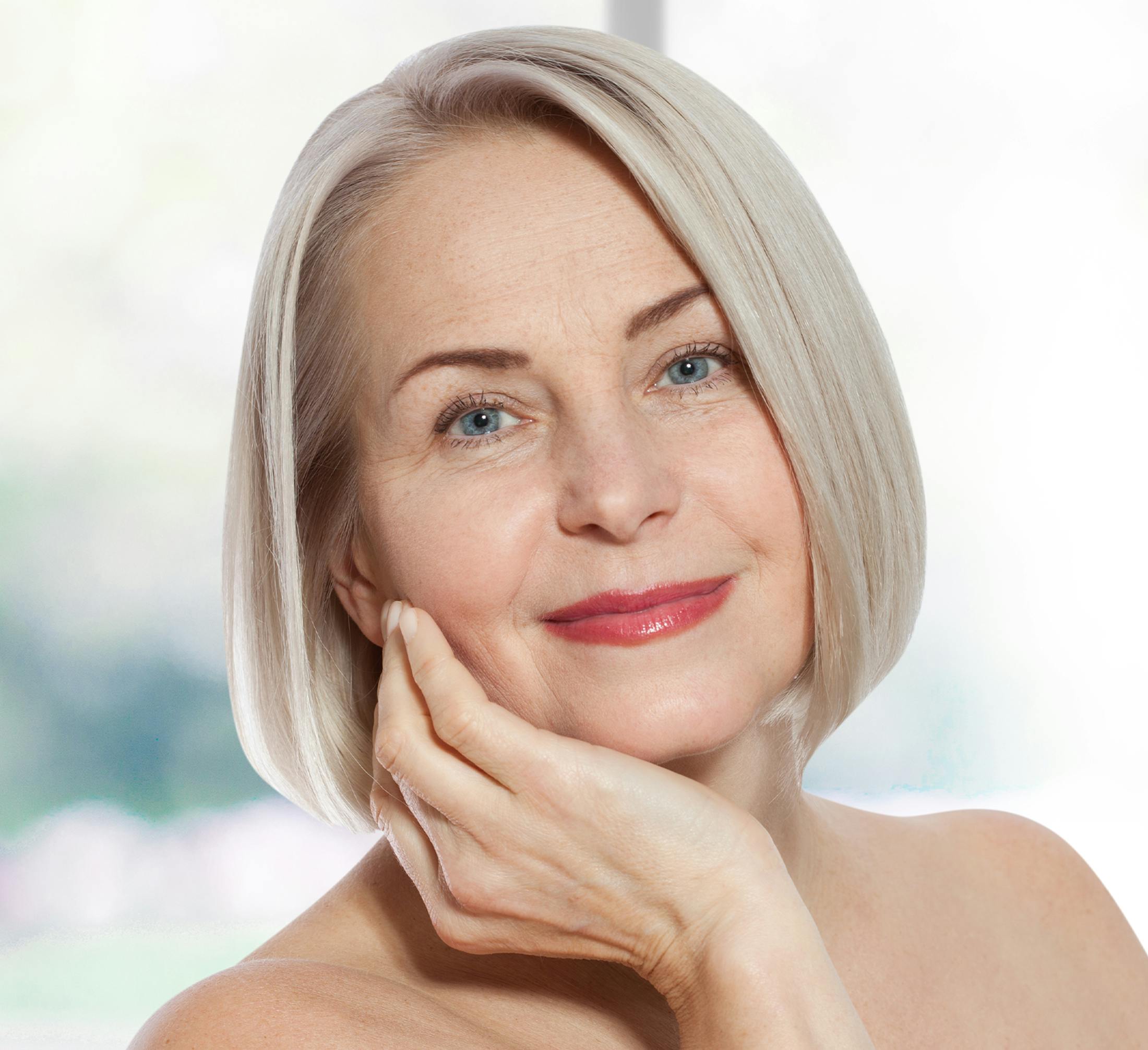woman with gray bob with hand resting on her jawline